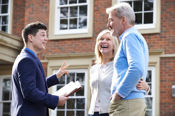 Makler zeigt älteres Paar um Haus zum Verkauf — Stockfoto