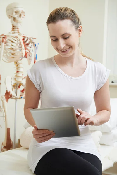 Vrouwelijke osteopaat In raadpleging van kamer met behulp van digitale Tablet — Stockfoto