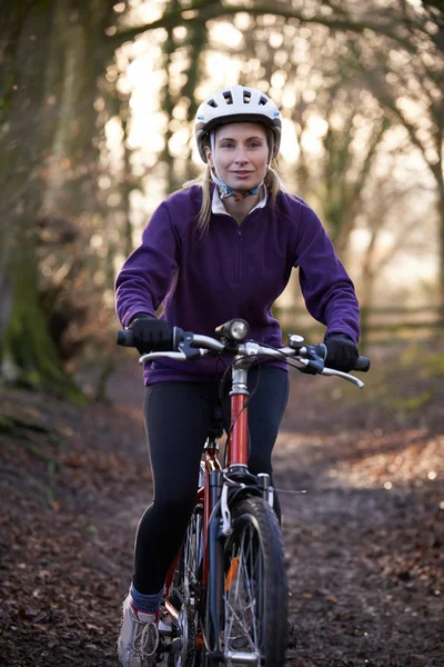 Mulher equitação montanha bicicleta através de bosques — Fotografia de Stock