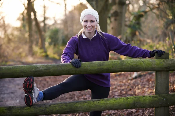 Woman Stretching On Run Through Winter Woodland — Stock Photo, Image