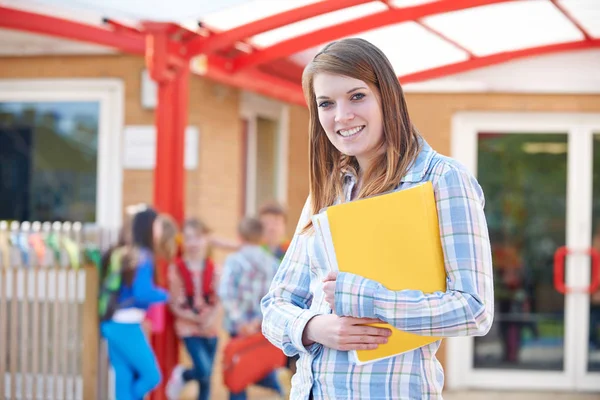 Porträt eines Lehrers, der mit Ordner auf dem Schulhof steht — Stockfoto