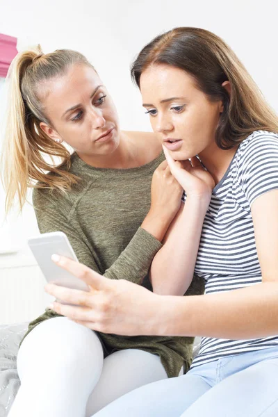 Tenåringsjente med venn blir mobbet av tekstmelding – stockfoto