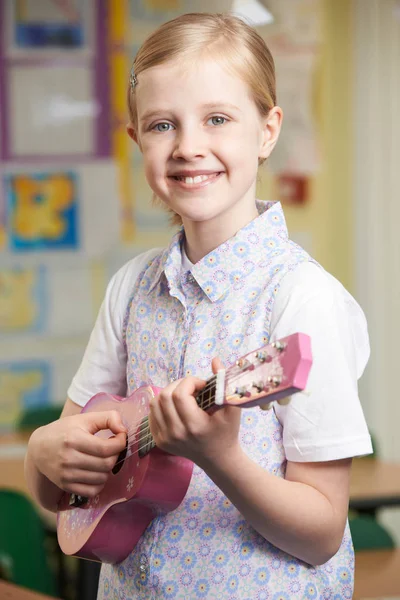 Menina aprendendo a jogar ukulele na escola Lição de música — Fotografia de Stock