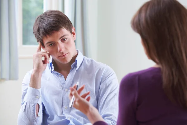 Depressiver junger Mann im Gespräch mit Berater — Stockfoto