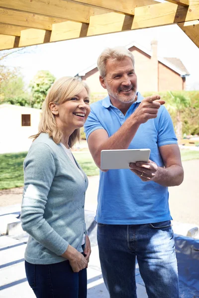 Reife Frau betrachtet Design auf digitalem Tablet mit Landschaft — Stockfoto