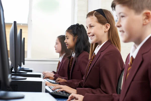Alumnos con uniforme escolar en clase de informática — Foto de Stock