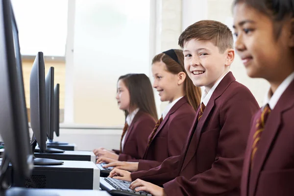 Alumnos con uniforme escolar en clase de informática — Foto de Stock