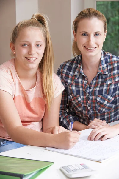 Tutor de casa feminino ajudando menina com estudos — Fotografia de Stock