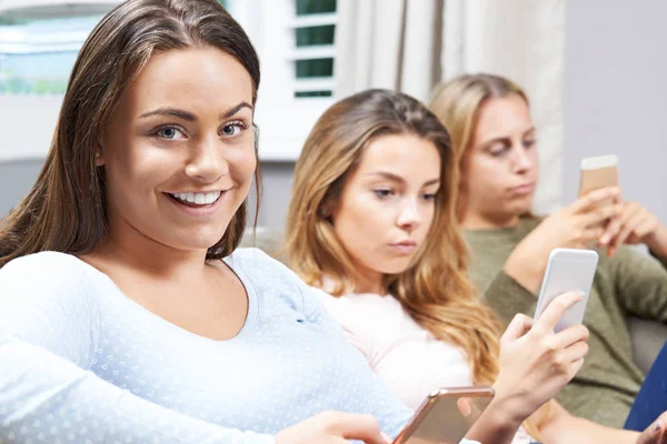 Grupo de chicas adolescentes usando teléfonos móviles en casa — Foto de Stock