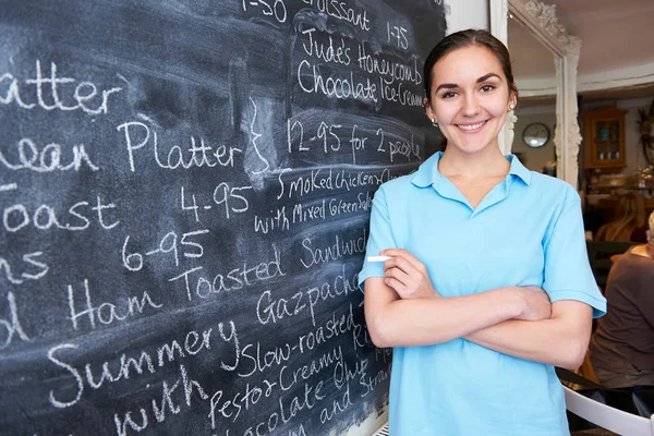 Kelnerka w restauracji pisania menu na tablicy — Zdjęcie stockowe