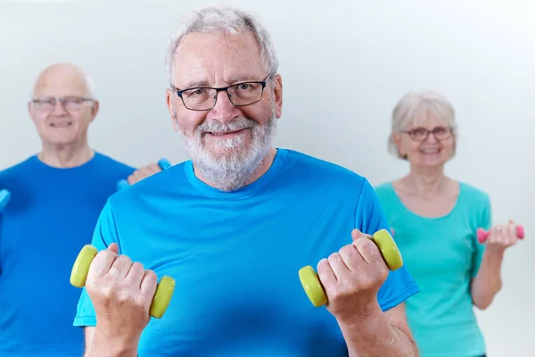 Grupo de personas mayores en clase de fitness usando pesas — Foto de Stock