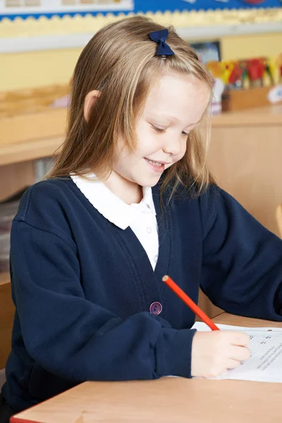 Vrouwelijke basisschool leerling werken bij Desk — Stockfoto