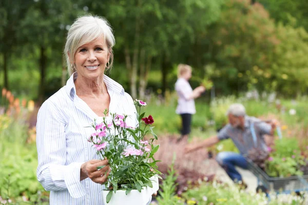 Oudere vrouw kiezen van planten in de tuin Center — Stockfoto