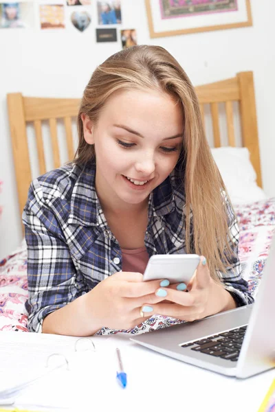 Ödev yaparken cep telefonu kullanan genç kız — Stok fotoğraf