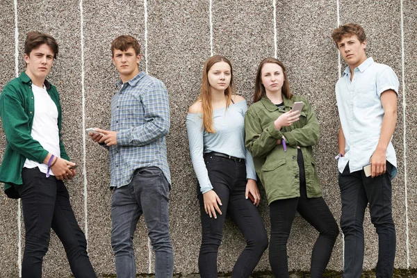 Grupp tonåringar dela textmeddelande på mobiltelefoner — Stockfoto