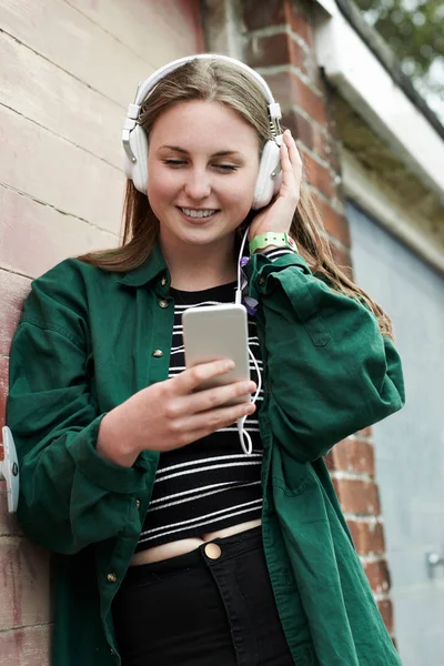 Nastolatka noszenie słuchawek i słuchanie muzyki w miejskich — Zdjęcie stockowe