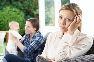 Sad Mature Woman Jealous Of Mother With Young Baby clipart