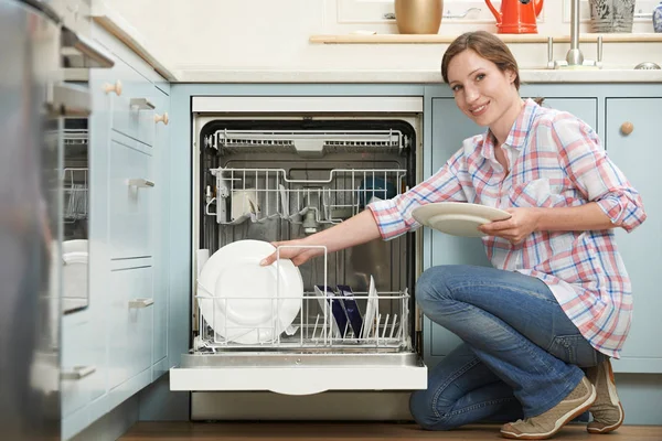Žena načítání myčka nádobí v kuchyni — Stock fotografie