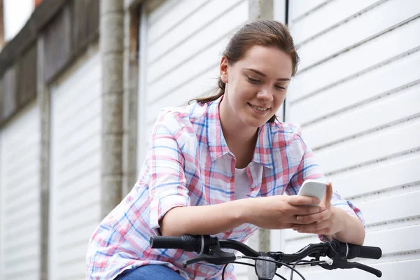 Tonårsflicka i Urban miljö med mobiltelefon medan Rider B — Stockfoto
