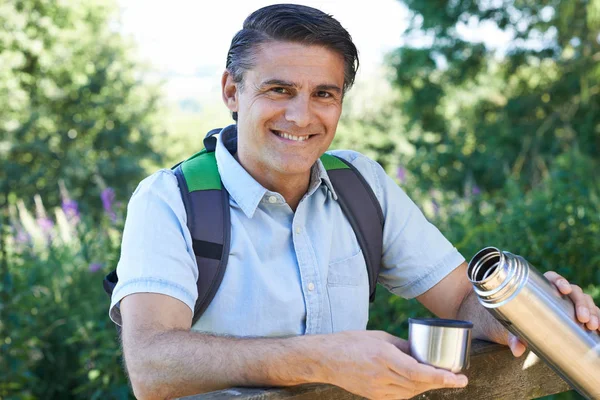 Mature Man Pouring Hot Drink From Flask On Walk — Stock Photo, Image