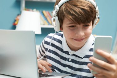 Genç çocuk yatak odasında teknolojisini kullanarak