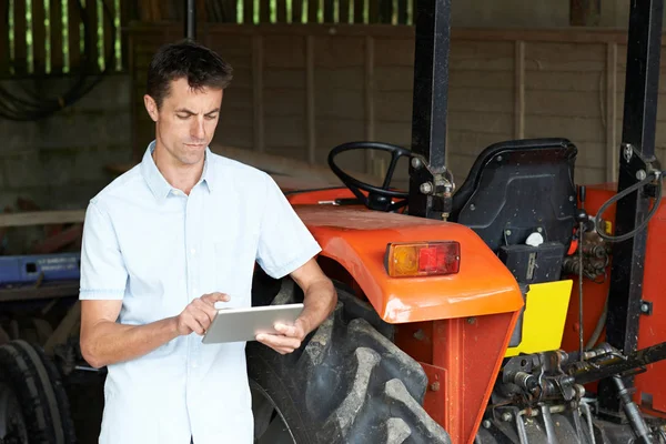 Rolnik stojący obok ciągnika za pomocą cyfrowego tabletu — Zdjęcie stockowe