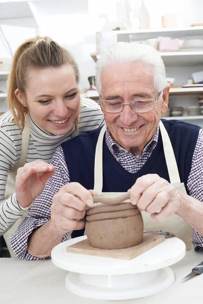 Старший человек с учителем в классе гончарного дела — стоковое фото