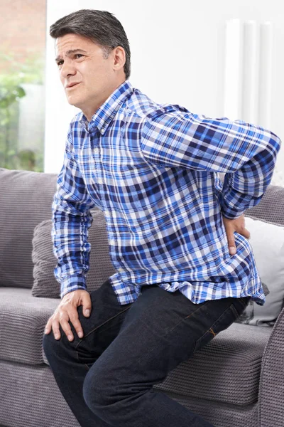 Hombre maduro que sufre de dolor de espalda en casa —  Fotos de Stock