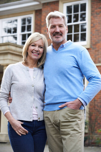 Портрет пожилой пары, стоящей снаружи дома
