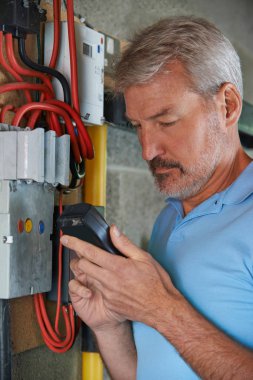 Elektrik ölçerden okuma alarak adam