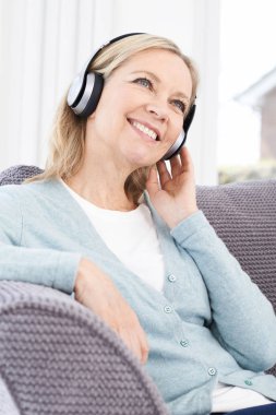 Olgun kadın kablosuz kulaklıklar müzik dinlemek