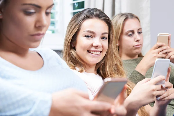 Grupo de chicas adolescentes usando teléfonos móviles en casa — Foto de Stock