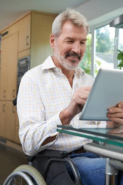 Gehandicapte Man In rolstoel met behulp van digitale Tablet thuis — Stockfoto