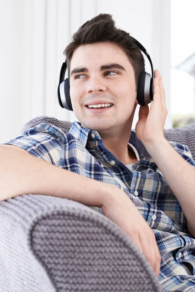 Młody człowiek słuchanie muzyki na słuchawkach bezprzewodowych — Zdjęcie stockowe