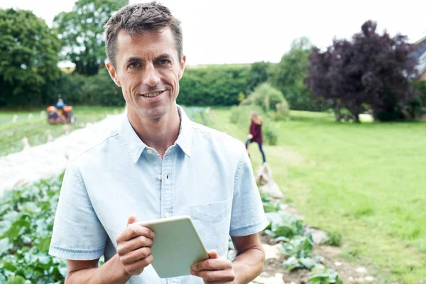 Trabajador agrícola masculino usando tableta digital en el campo — Foto de Stock