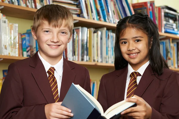 Eleverna bär skola enhetlig läsebok i biblioteket — Stockfoto