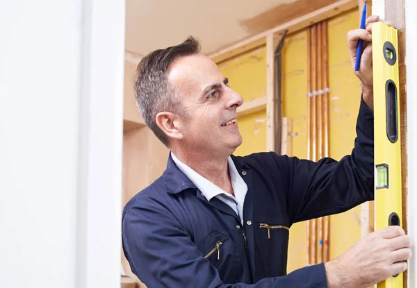 Bauarbeiter überprüfen Arbeit mit Wasserwaage — Stockfoto