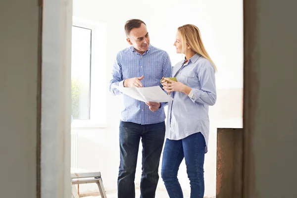 Vrouw ontmoeting met Architect of bouwer In gerenoveerd onroerend goed — Stockfoto