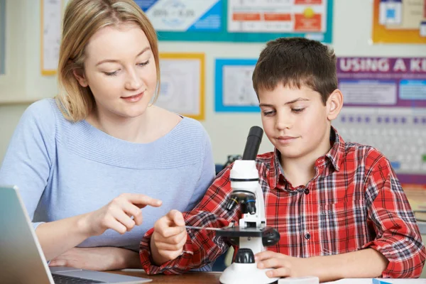 理科の授業で顕微鏡を用いた男性学生と先生 — ストック写真