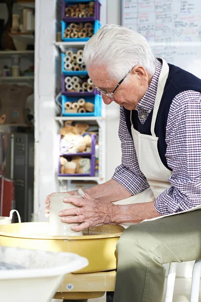 Hombre mayor trabajando en la rueda de cerámica en el estudio —  Fotos de Stock