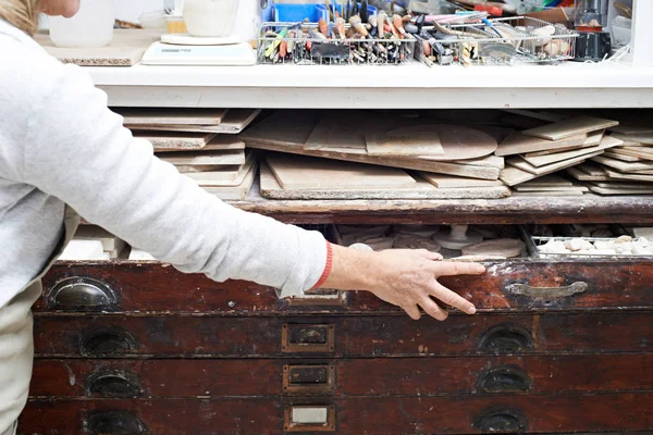 Mujer en el estudio de cerámica quitando materiales del pecho del plan —  Fotos de Stock