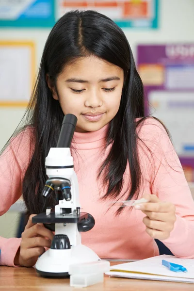 女学生用显微镜在科学课 — 图库照片