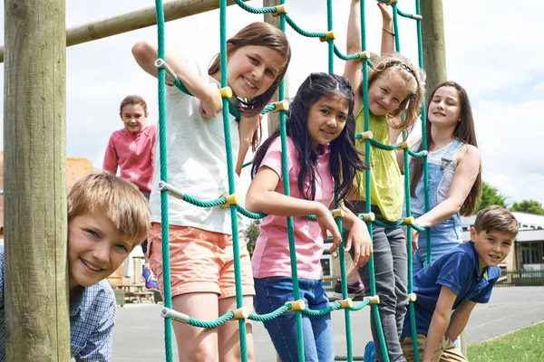 Retrato de los alumnos de la escuela jugando en el marco de escalada —  Fotos de Stock