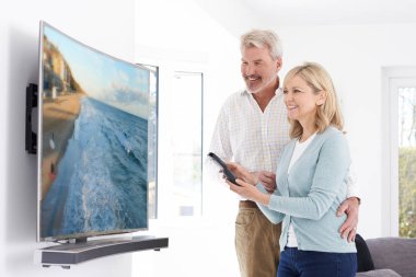 Olgun çift evde yeni kavisli ekran televizyonlu