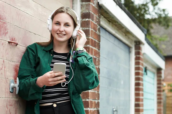 Adolescente ragazza indossando cuffie e ascoltando musica in urbano — Foto Stock