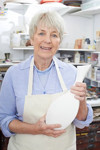 Retrato de mulher sênior segurando vaso no estúdio de cerâmica — Fotografia de Stock