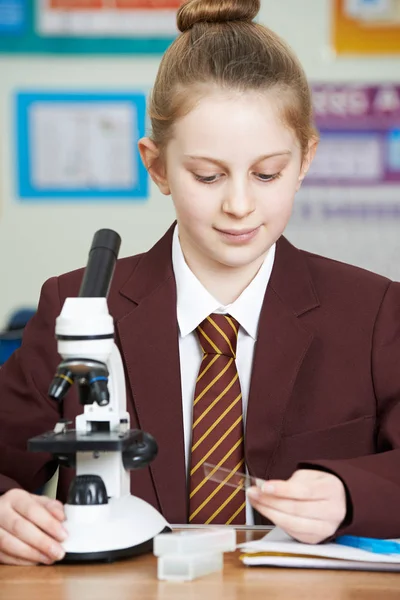 Vrouwelijke leerling Microscoop met wetenschap les — Stockfoto