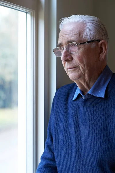 Ανώτερος άνθρωπος που πάσχουν από κατάθλιψη, κοιτάζοντας έξω από το παράθυρο — Φωτογραφία Αρχείου