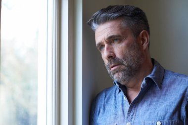 Pencereden dışarı bakıyor depresyon muzdarip adam Olgun