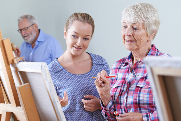 Seniors Attending Painting Class With Teacher